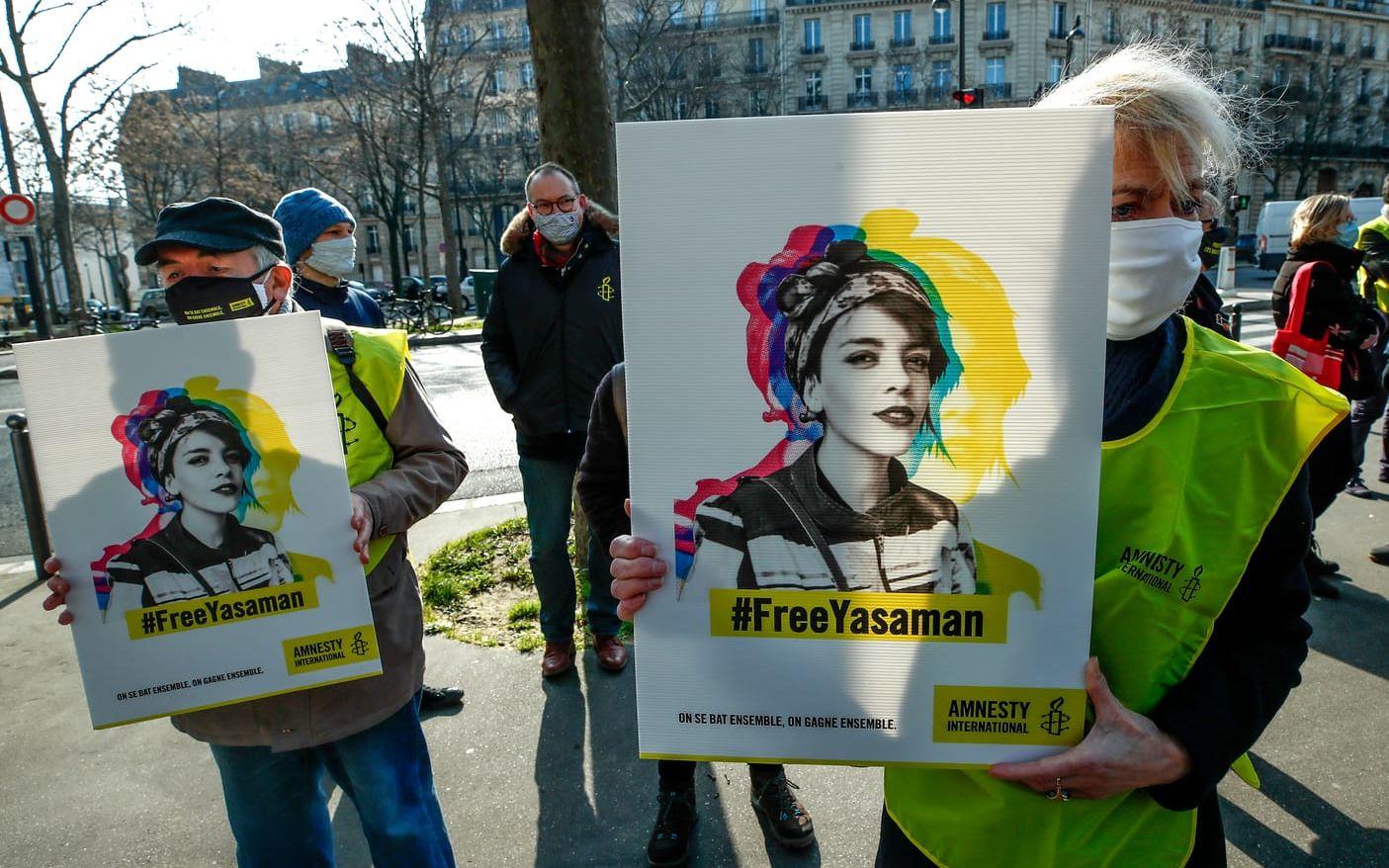 Människorättsaktivister protesterar med plakat i Paris  på internationella kvinnodagen 2021 nära Irans ambassad. Deras budskap? Släpp den fängslade iranska Kvinna, liv, frihet-aktivisten Yasaman Aryani fri. 2019 dömdes hon till 16 års fängelse för att ha delat ut blommor i tunnelbanan utan slöja.